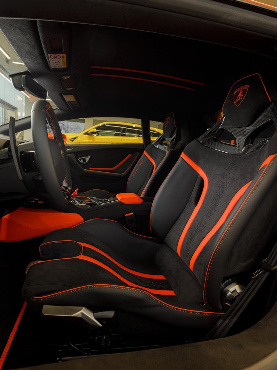 Explore the stunning interior of a Lamborghini Huracan with sleek black and orange detailing.