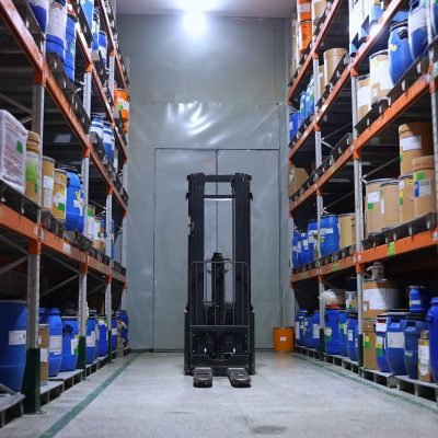 A well-organized pharmaceutical warehouse with shelves and a forklift in Islamabad, Pakistan.